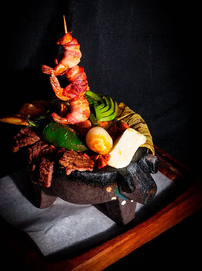 A molcajete of grilled meats and vegetables